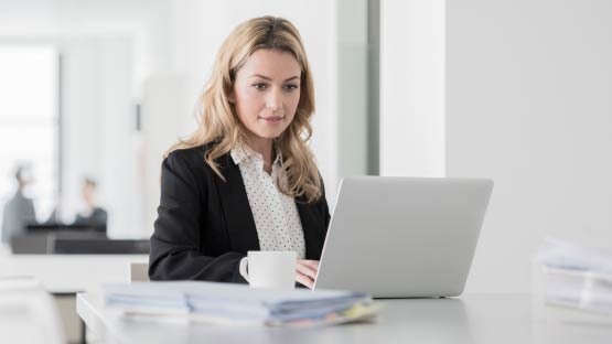 Woman sitting at desk working on a laptop