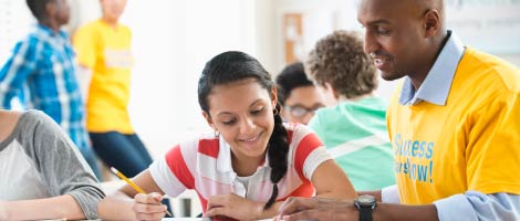 young girl sitting at table with tutor