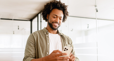 A man smiling and looking at a tablet, representing the provider search tool.