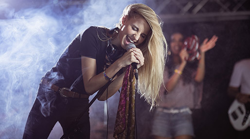 Blonde girl leaning into a microphone singing