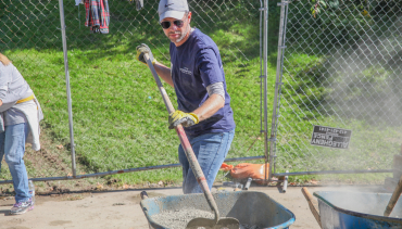 photo of a man mixing cement for a playground build