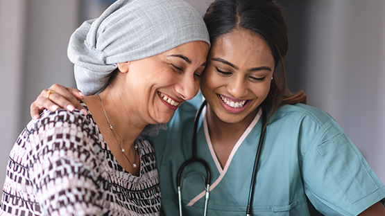two women, one a doctor and one a patient, smiling together