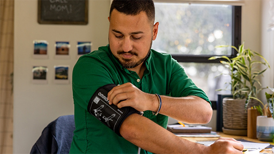 a man at home checking his blood pressure