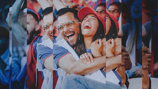 a man and a woman, both Bills fans, cheering and hugging at a game