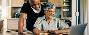 senior couple smiling and looking at a laptop computer
