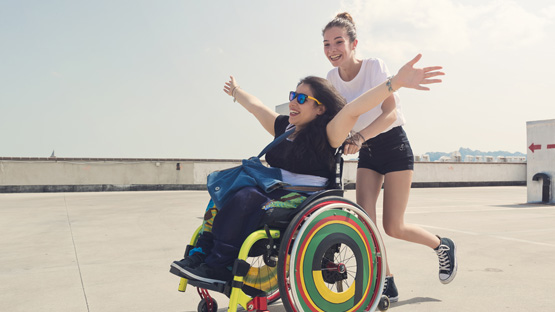 a women pushing another women in a wheel chair outside fast