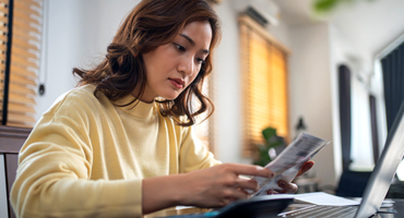 Woman checking the details on a health care documentation, thinking about the high cost of health care.