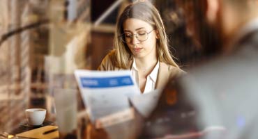 young female adult reading about her employee benefits plan