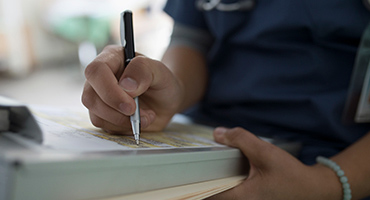 close up shot of a persons hand filling out a form