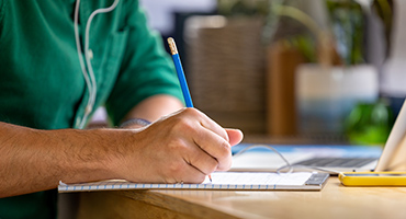 a young person writing on a paper tablet