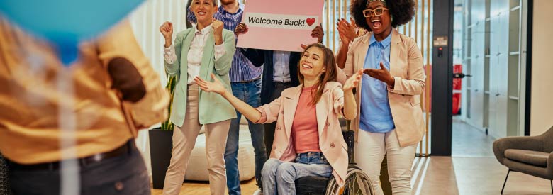 a women in a wheel chair celebrating with her co workers