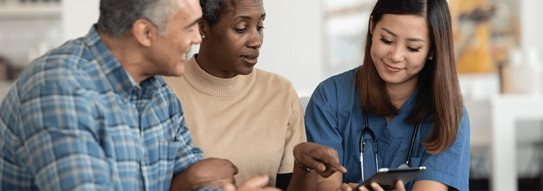 photo of two adults talking to a nurse or medical professional