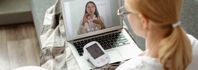 female on her laptop talking to a doctor though a virtual visit