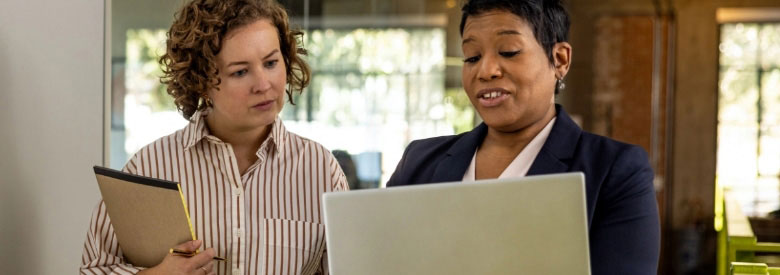 Two female Highmark health insurance staffers (one white, one black) discussing the no surprises act.