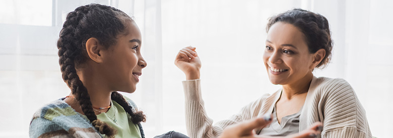 two young ladies talking one has two braids