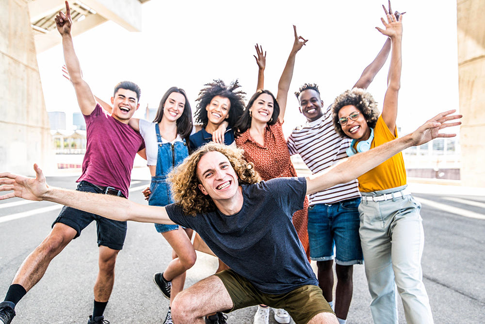 A celebratory shot of 7 diverse individuals with arms outstretched, representing the Neighborhood Learning Alliance of Southwestern Pennsylvania.