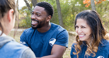 a man and a woman smiling to a group of people off camera