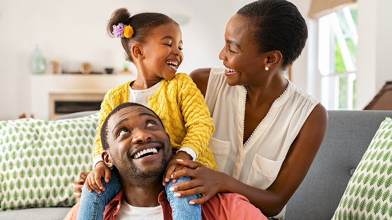 mother, father and their daughter all smiling and laughing together