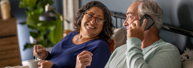 photo of a man and women on their couch talking on the phone