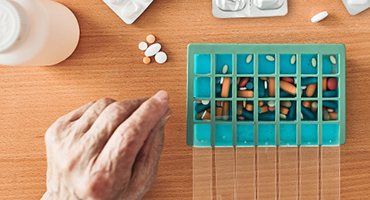 An older adult sorts their many medications, representing Highmark's Medicare Part D’s help with easily managing prescriptions.
