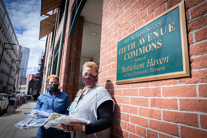 Dr. Christina Wilds (left), Manager of Community Health and Programs at Highmark Health, delivers face masks to Dr. Sharon Higginbothan (right), Chief Operating Officer for Bethlehem Haven shelter in Uptown. 