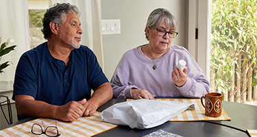 Photo of a senior man and woman with glasses talking about medical concerns