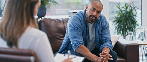 A middle-aged man talking to a doctor about treatments for anxiety.