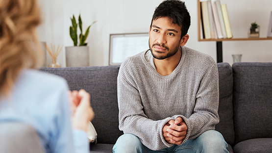 Young man talking to a doctor about types and symptoms of depression.