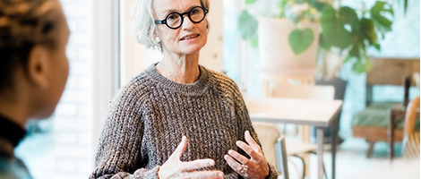 Older female adult speaking to a group about mental health organizations.