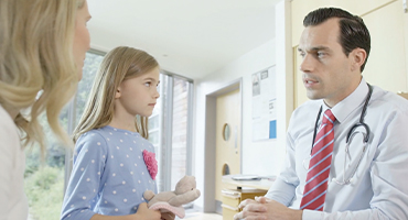 a doctor talking to a mother and daughter