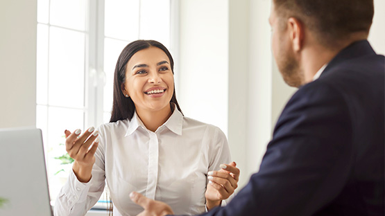 A woman and man happily in a conversation showing Highmark Ventures team spirit. 