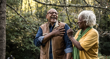 male and female older couple walking outside laughing