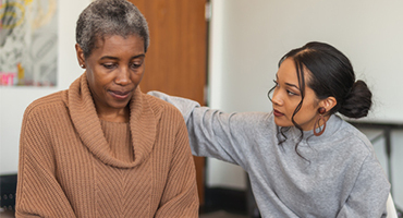 older woman being consoled by a youger woman