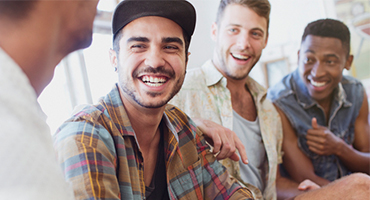 group of young men sitting together and laughing