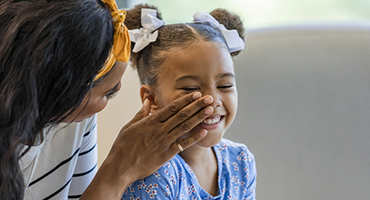 Mother wiping her daughter's face