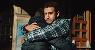 man holding up and hugging his child in his arms