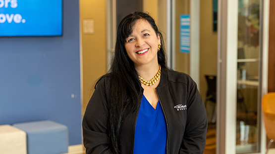 A smiling middle-aged professional wearing a Highmark Direct jacket offers guidance on D-SNP benefits.