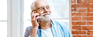 A smiling senior confidently talks on the phone, representing the helpful support for Highmark members.