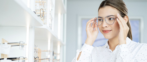 woman trying on or adjusting her eye glasses 