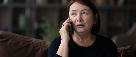 A woman is on the phone while at home.