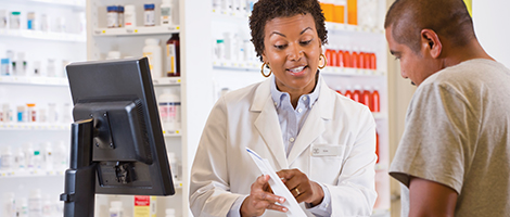 A pharmacist is reviewing a patient's prescription medication paperwork with him. 