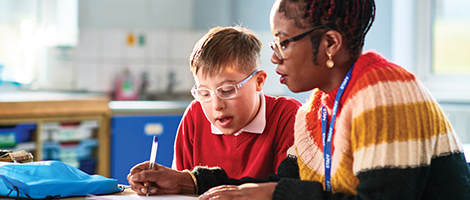 A woman is helping a child with his homework. 